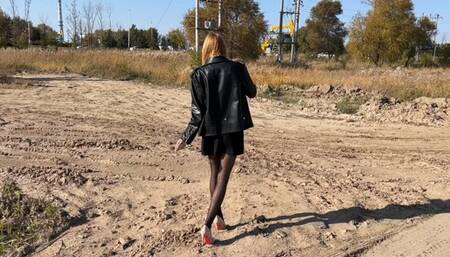 A girl in high-heeled shoes walks through sticky mud and gets her shoes dirty