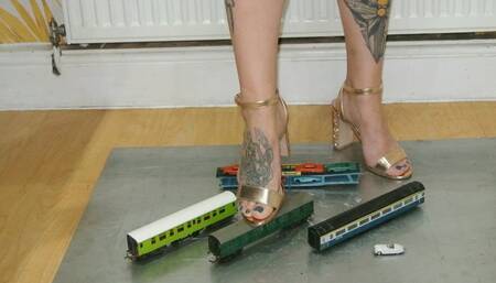 Giantess Atari Queen crushes and destroys some train coaches and a tiny car in gold blocky heels closeup ground view