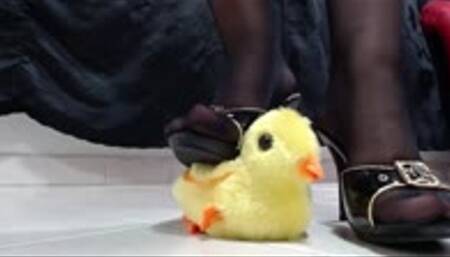 Crushing crush a toy chicken in heels and sandals with nylons black and long toenails