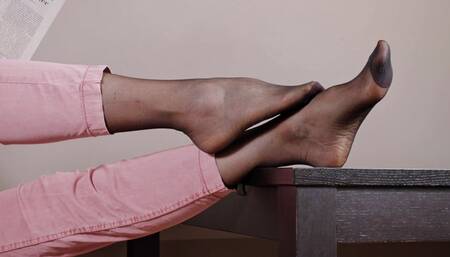 Mrs S is reading the News wearing black Stockings under her Trousers