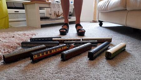 GIANTESS Charn crushes 10 toy model train coaches in black wedges closeup ground view
