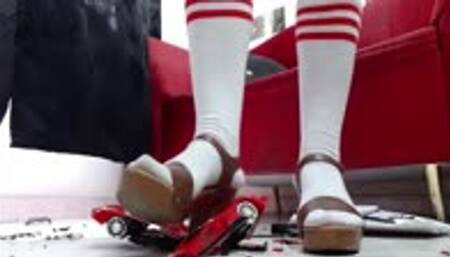crushing RC toycar in white socks and hard soled sandals in 1000 pieces