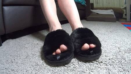Toe wiggling in plush black slippers TS