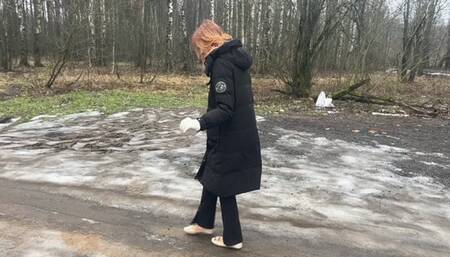 A girl walks in ballet flats on a very bad road where there is slippery ice and slippery mud, her ballet flats slip on such a road and get very dirty