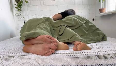 female male bare feet under the blanket