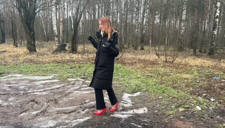 A girl in sexy high-heeled shoes deliberately decided to walk along a dirty forest path, dirtying her heels and destroying them
