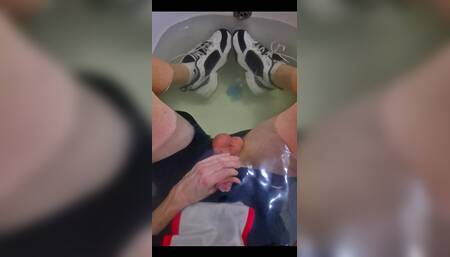 Wearing a Soccer Uniform and Nike Sneakers in Relaxing in a Tub Full of Water