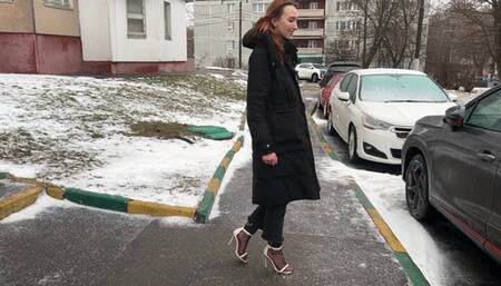 A girl in beautiful high-heeled sandals and nylon stockings likes to have fun with the pedals of a car