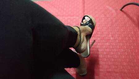 The beautiful Angelin's mules hang from her feet as she stands with her legs crossed (1)