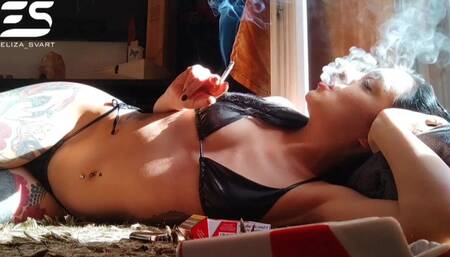 Relaxing smoke in a tiny leather bikini
