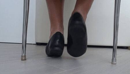 Play of shoes and bare feet under the chair a