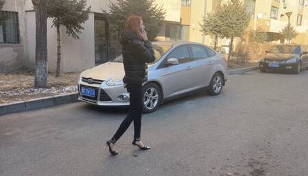 A girl in high-heeled shoes was waiting for her friend at her house and talking on the phone, not noticing the car that crushed her foot and shoe