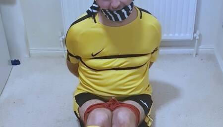 Footballer in yellow and black kit struggling to get out of tight bondage 1